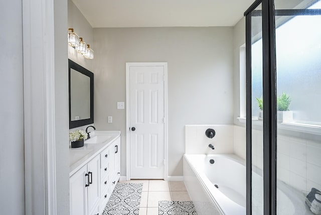 bathroom with a garden tub, tile patterned floors, a sink, double vanity, and baseboards