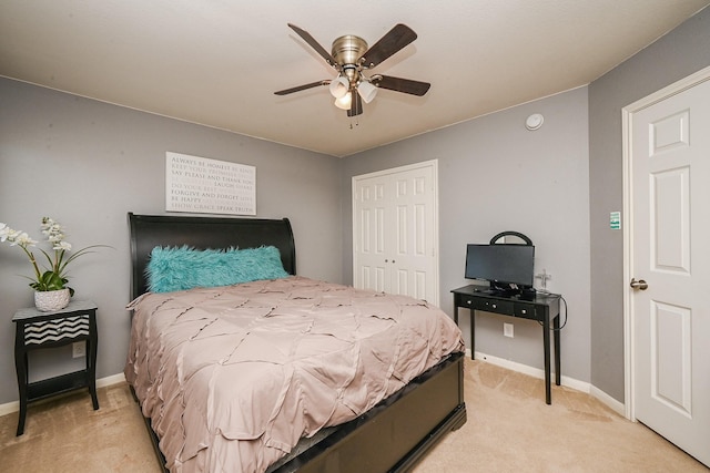 bedroom with a closet, a ceiling fan, baseboards, and light carpet