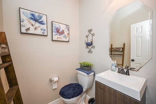 bathroom featuring baseboards, toilet, and vanity