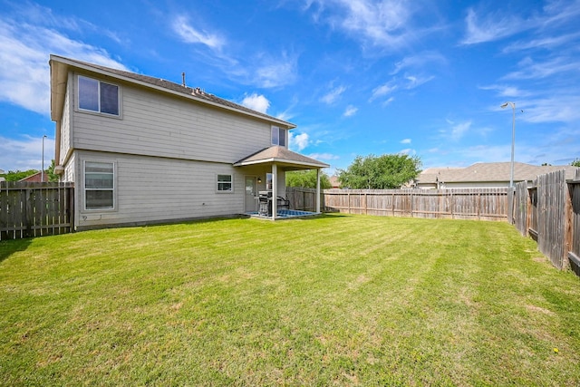 back of house featuring a yard and a fenced backyard