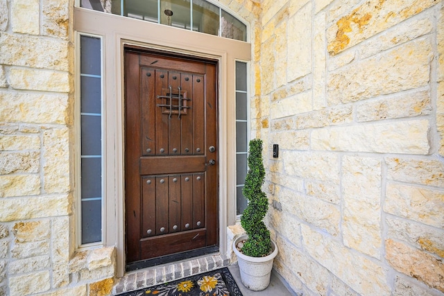 doorway to property featuring stone siding