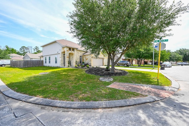 view of front of house with an attached garage, stone siding, a front lawn, and fence