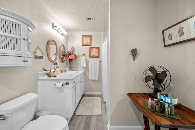 8703 County Road 48, Rosharon, TX 77583 - full bath with a textured ceiling, toilet, vanity, baseboards, and a shower with curtain
