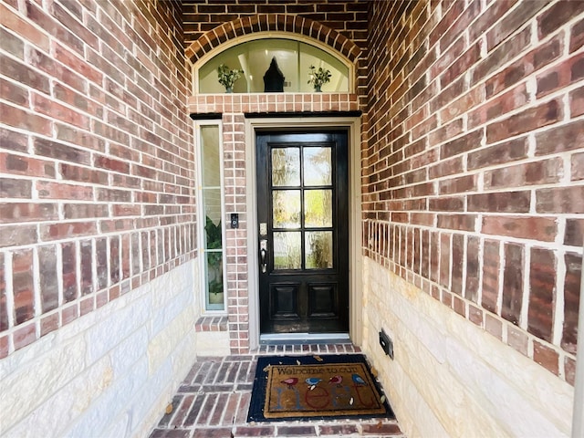 doorway to property featuring brick siding