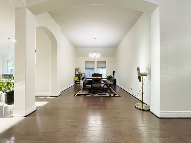 dining room with an inviting chandelier, arched walkways, baseboards, and wood-type flooring