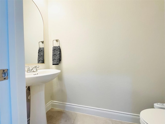 bathroom with baseboards, toilet, and tile patterned floors