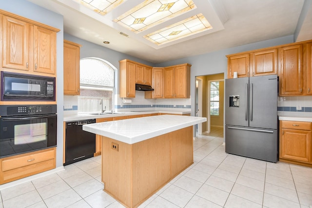 kitchen with black appliances, decorative backsplash, a healthy amount of sunlight, and a sink