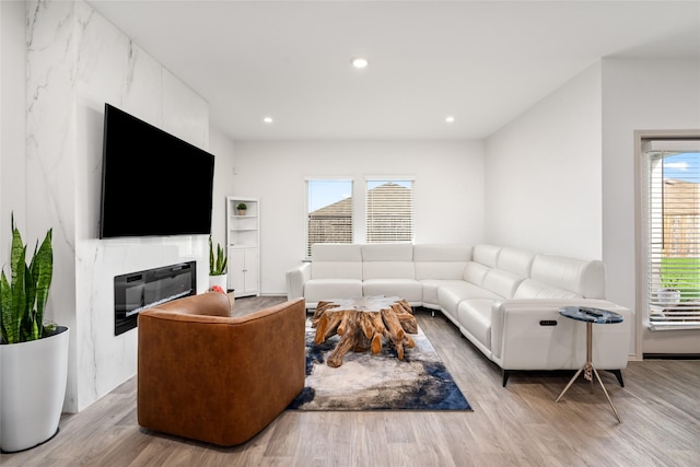 living room with wood finished floors, a high end fireplace, and recessed lighting