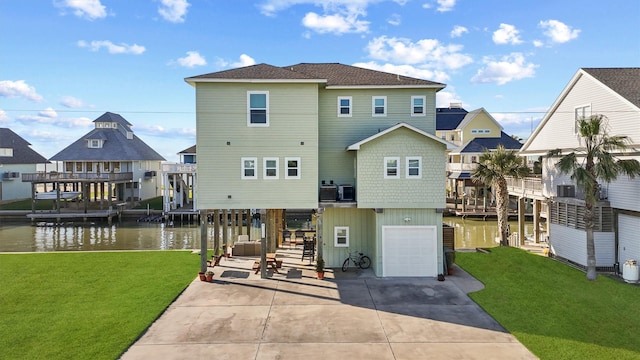 23006 Martes St, Galveston, TX 77554 - rear view of property with a garage, concrete driveway, a water view, and a lawn