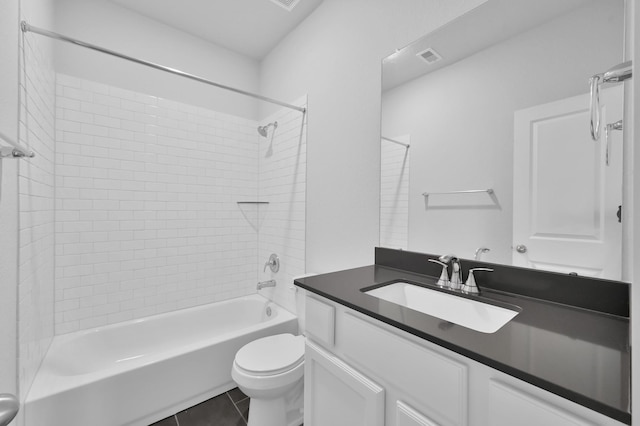 bathroom with tile patterned floors, bathing tub / shower combination, toilet, visible vents, and vanity
