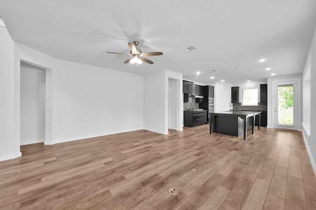 unfurnished living room featuring a ceiling fan, light wood finished floors, visible vents, and recessed lighting