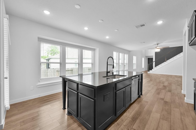 kitchen with dishwasher, visible vents, a healthy amount of sunlight, dark cabinetry, and a sink