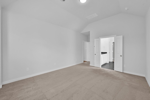 unfurnished bedroom featuring vaulted ceiling, baseboards, and carpet floors