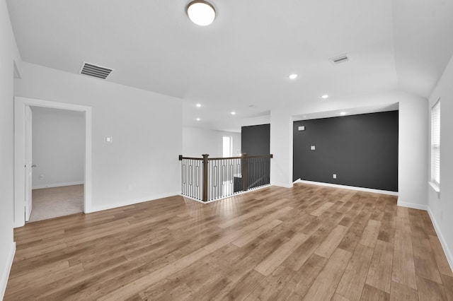 unfurnished room with baseboards, light wood-style flooring, visible vents, and recessed lighting