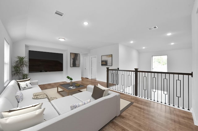 living area featuring baseboards, wood finished floors, and visible vents