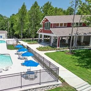 community pool featuring fence, a lawn, and a patio