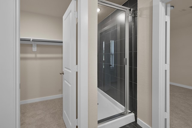 bathroom featuring a shower stall, baseboards, visible vents, and a spacious closet