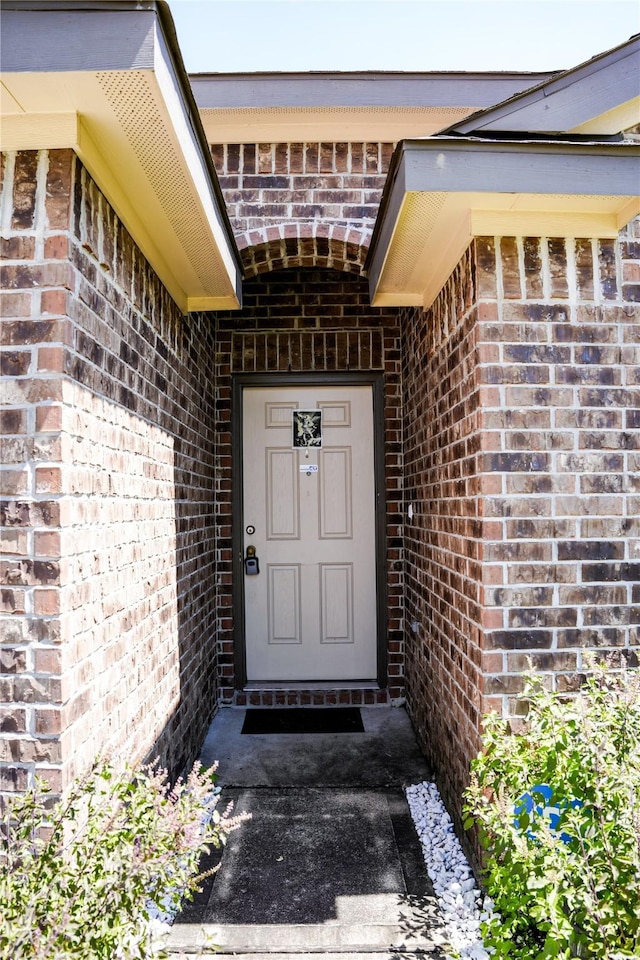 doorway to property featuring brick siding
