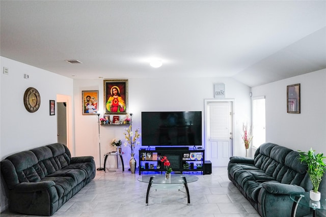 living area with visible vents and vaulted ceiling