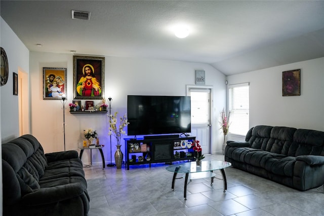 tiled living area featuring visible vents and lofted ceiling