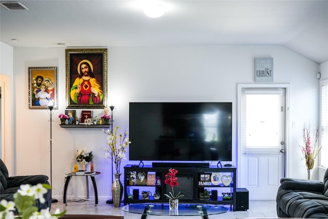 living room featuring visible vents, tile patterned flooring, and lofted ceiling