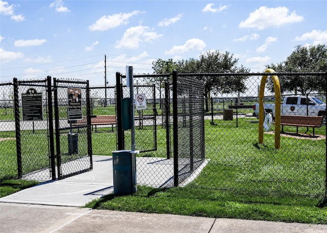 view of gate with fence and a lawn