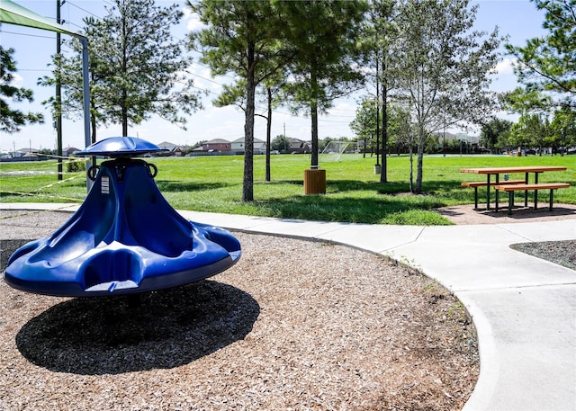 view of home's community with a lawn and playground community