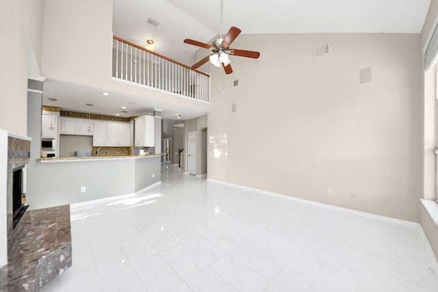 4902 Bellmead Dr, Missouri City, TX 77459 - unfurnished living room featuring ceiling fan, light marble finish flooring, high vaulted ceiling, a fireplace, and baseboards
