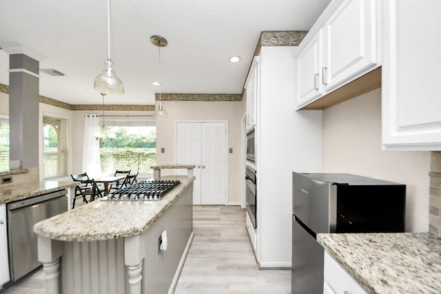 4902 Bellmead Dr, Missouri City, TX 77459 - kitchen featuring stainless steel appliances, white cabinets, a kitchen island, light wood finished floors, and light stone countertops