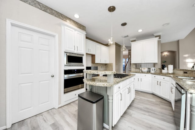 4902 Bellmead Dr, Missouri City, TX 77459 - kitchen featuring appliances with stainless steel finishes, a kitchen island, a sink, light wood-style floors, and recessed lighting
