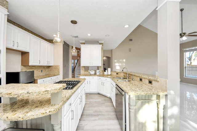 4902 Bellmead Dr, Missouri City, TX 77459 - kitchen featuring stainless steel appliances, a sink, a peninsula, decorative backsplash, and light wood-style flooring