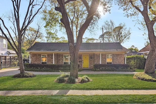 single story home with brick siding, fence, and a front lawn