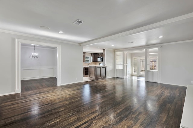unfurnished living room featuring crown molding, dark wood finished floors, a chandelier, and visible vents