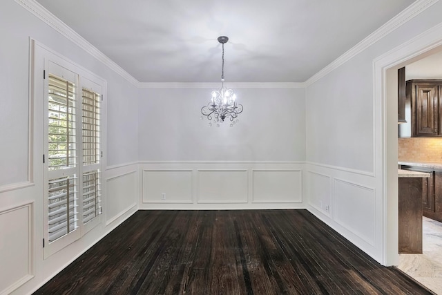 unfurnished dining area with ornamental molding, wainscoting, a chandelier, and dark wood-type flooring