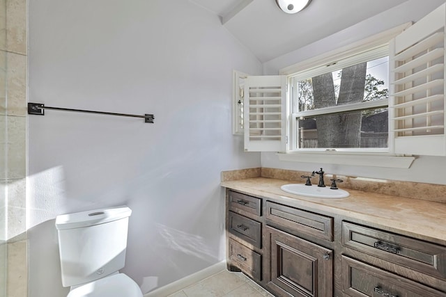bathroom with toilet, vaulted ceiling, tile patterned flooring, and vanity