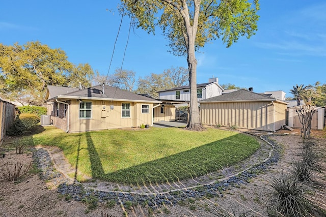 back of house with an outdoor structure, a fenced backyard, central AC unit, a patio area, and a yard