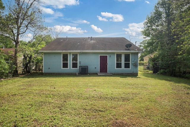 back of house featuring central air condition unit, entry steps, fence, and a lawn