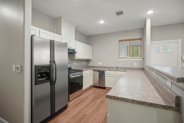 kitchen with light wood-style flooring, white cabinetry, under cabinet range hood, visible vents, and stainless steel appliances