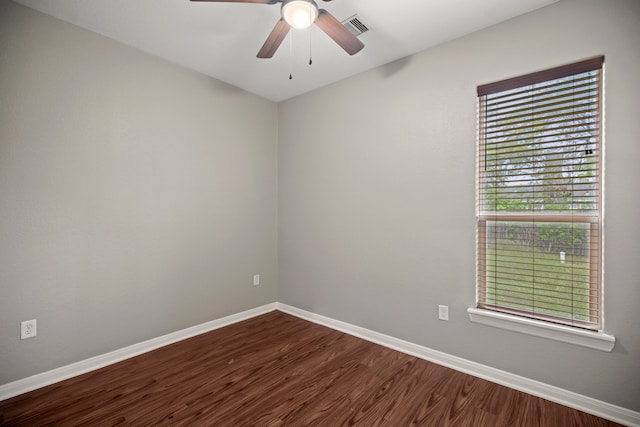 unfurnished room with visible vents, baseboards, a ceiling fan, and dark wood finished floors