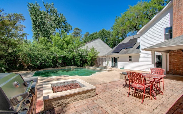 pool with a fenced backyard, a fire pit, a patio, outdoor dining space, and area for grilling