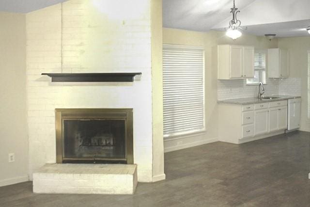 3835 Brookwind Dr, La Porte, TX 77571 - unfurnished living room with vaulted ceiling, a sink, baseboards, dark wood finished floors, and a fireplace