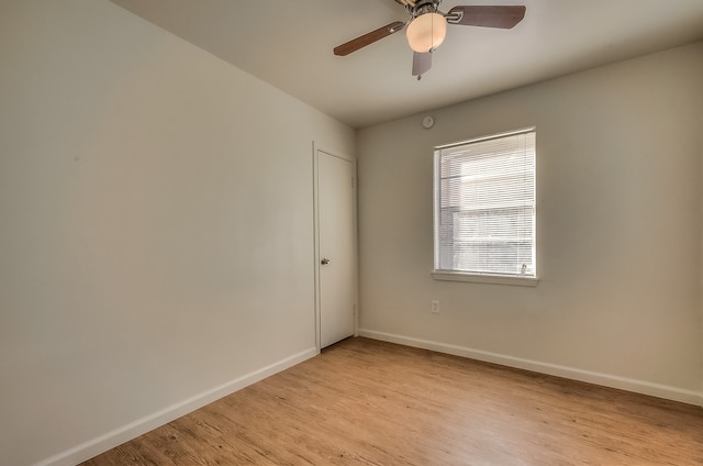spare room with light wood finished floors, baseboards, and a ceiling fan