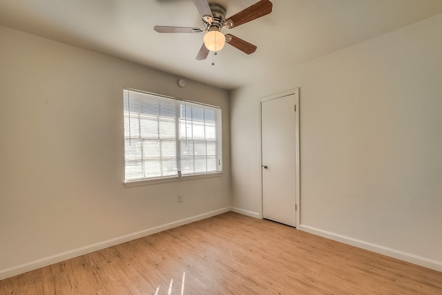 empty room featuring light wood finished floors, baseboards, and ceiling fan