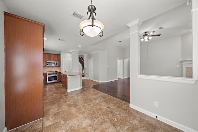 kitchen with open floor plan, stainless steel microwave, range, and visible vents