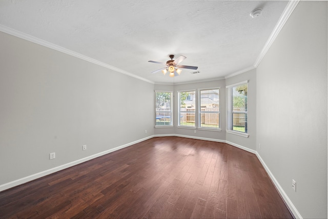spare room with baseboards, ornamental molding, a ceiling fan, visible vents, and dark wood finished floors