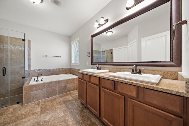 bathroom featuring double vanity, a garden tub, a sink, and a stall shower