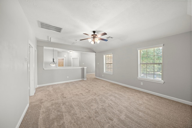 unfurnished living room featuring baseboards, light carpet, attic access, a ceiling fan, and visible vents