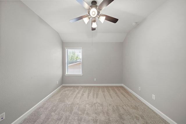 spare room with light carpet, baseboards, a ceiling fan, and lofted ceiling