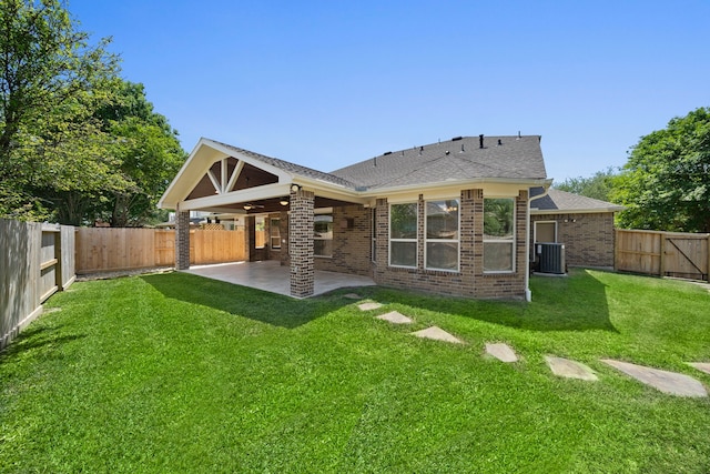 rear view of property with cooling unit, a patio area, a fenced backyard, and a lawn