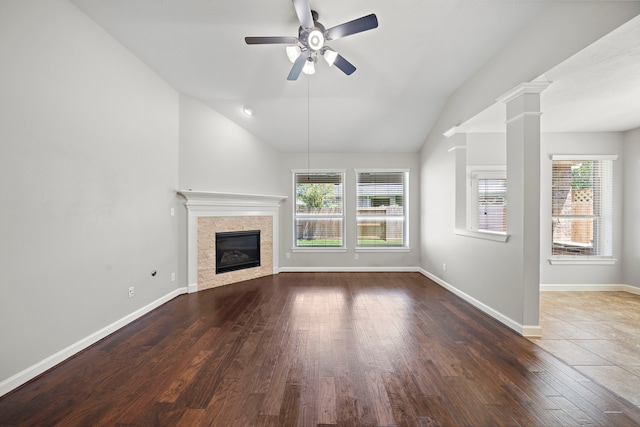 unfurnished living room featuring baseboards, ceiling fan, wood finished floors, vaulted ceiling, and a glass covered fireplace